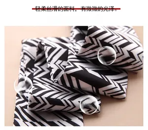 Close-up of soft black and white geometric silk scarf fabric with smooth texture