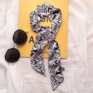 Macro detail of black and white herringbone pattern twilly scarf with care label