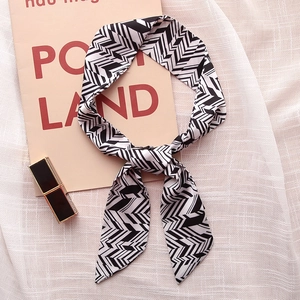 Detail of a black and white geometric arrow pattern narrow scarf with pointed ends