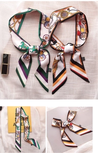 Detailed macro view of long printed silk scarves featuring carriage patterns and twill design