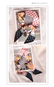 Detail of silk-like floral scarf with pink and black heart patterns and artistic prints