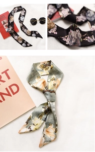 Close-up of floral satin skinny scarf with vintage coins and magnolia print details