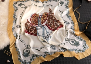 Detailed view of horse motif silk scarf with golden baroque pattern and equestrian details