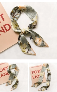 Detail of floral printed silk scarf in sage green featuring elegant magnolia patterns