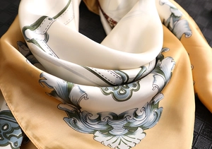 Detail of baroque pattern silk scarf with golden scrolls and hand-rolled hem edges