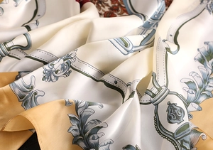 Detailed view of luxury silk satin scarf with vintage gold and blue baroque patterns