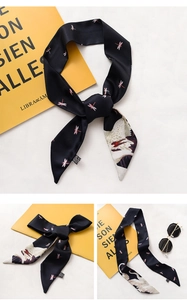 Macro detail of black floral twilly scarf with dragonfly and crane pattern prints