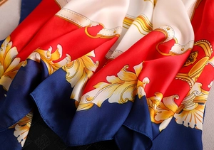 Close-up of printed silk scarf with baroque gold patterns and satin texture finish