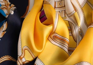 Close-up of silky scarf texture with golden Baroque pattern and elegant draped fabric