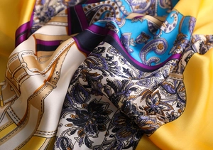 Detail showing the silky texture and vibrant paisley pattern of a colorful silk scarf