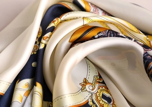 Detailed view of luxurious silk scarf fabric with baroque scroll patterns and chain elements