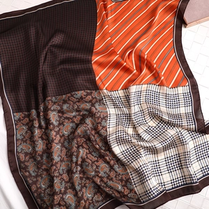 Détail d'un foulard en soie d'automne avec motifs paisley et rayures orange élégantes