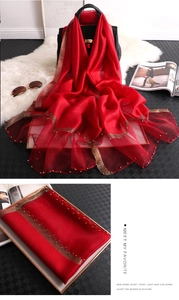 Detail of red summer silk scarf with golden edge trim and delicate pearl beads