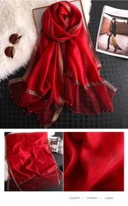 Detail of red silk sunscreen scarf with gold bead trim and shimmering metallic edges
