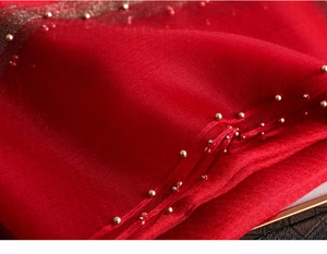 Macro shot of dark red sheer silk scarf featuring gold and silver beaded edge details