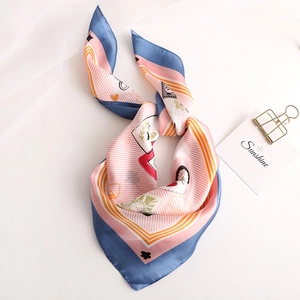 Détail d'un foulard en soie avec motifs de cartes de poker et rayures pastel