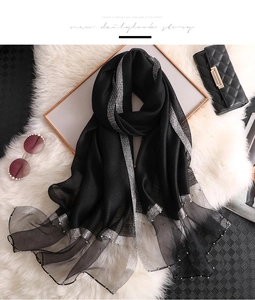 Detail of black silk scarf with silver shimmering edges and white faux pearl accents