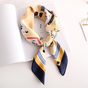 Vue détaillée du foulard en soie aux motifs pop art de cartes en jaune et bleu