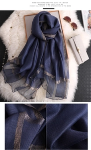 Detail of navy blue silk scarf with champagne gold metallic trim and beadwork