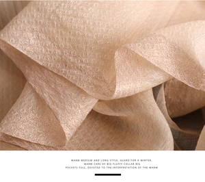 Detail showing champagne silk scarf with textured weave and beaded gold trim