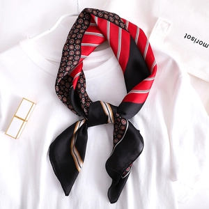 Détail d'un foulard élégant en soie avec motifs géométriques sur un t-shirt blanc