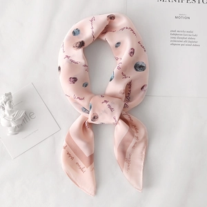 Détail d'un foulard en soie rose avec imprimé pelote de laine et texture douce