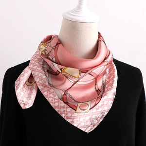 Vue détaillée d'un foulard en soie rose avec motifs de chaînes dorées et boucles de ceinture