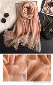 Detail of sheer silk scarf with beaded gold edges and fine twill fabric texture
