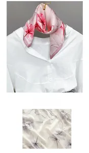 Detail of silk-like scarf with floral Lycoris print and soft texture on white shirt
