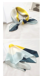 Detail of silk scarf with geometric yellow and blue color block and satin finish