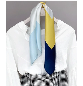 Tie-dye satin scarf styled over white shirt and houndstooth skirt for a chic look