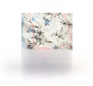 Detailed view of silk-like scarf featuring ink bamboo patterns and soft blue edges