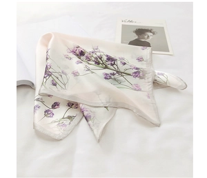 Detailed close-up of floral silk scarf with lavender print on a bright white fabric