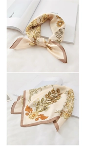 Detailed view of floral pattern and hemmed edge on champagne tie-dye silk scarf