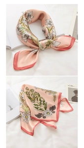 Detail of pink floral faux silk scarf with elegant lily print and hand-rolled edges