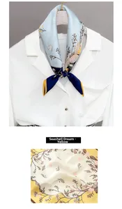 Detail of silk scarf with shell print and smooth texture draped on a white shirt
