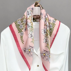 Pink floral faux silk scarf with lily prints hanging on a hanger for spring and autumn