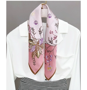 Detail of silk scarf with shell prints and brown edges on a wooden hanger