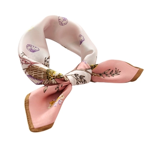 Pink silk scarf with shell and floral print patterns on a clean white background