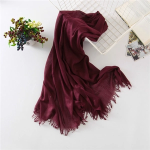 Close-up of wine red linen cotton scarf with delicate fringe edges and soft texture