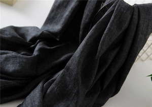 Detail of dark grey cotton linen scarf showing coarse woven texture and natural raw edges