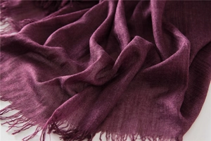 Macro shot of deep purple cotton linen scarf showing soft fabric texture and fringe edges