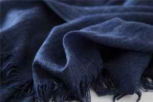 Close-up of deep blue cotton linen scarf showing fine fringe and soft woven texture