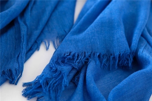 Detail of dark blue linen scarf showing fine weave texture and delicate frayed fringe edges