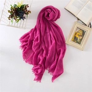 Detail of rose red cotton linen scarf with soft fringe edges and woven texture