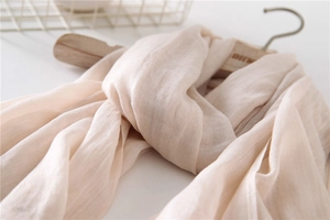 Close-up of lightweight light beige cotton linen scarf showing delicate woven texture