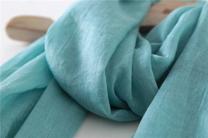 Close-up of turquoise cotton linen scarf showing breathable plain weave texture