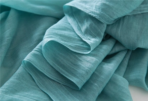 Close-up of lightweight lake blue cotton linen scarf fabric with breathable fine texture