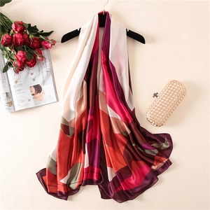 Artistic color block silk scarf displayed with roses and fashion magazines