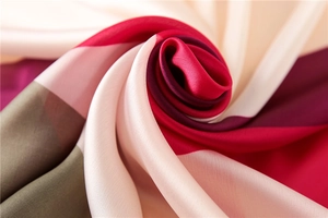 Macro shot of silk satin scarf showing smooth texture and colorful patchwork design